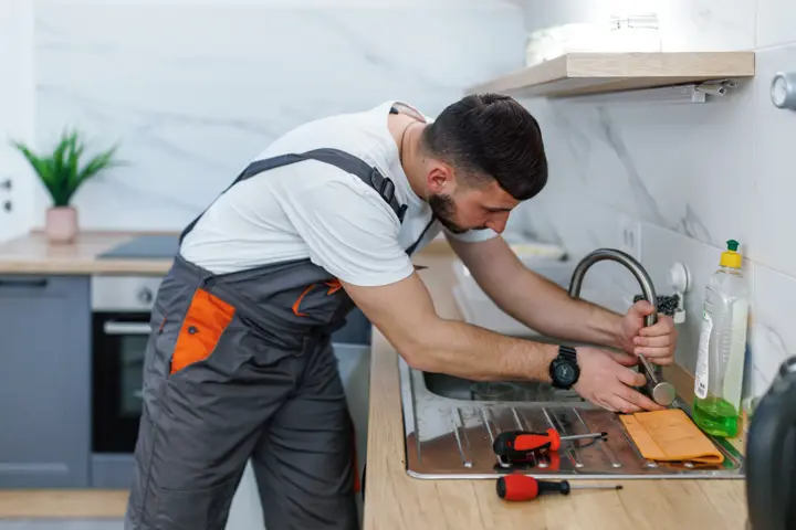 Plumber working on a kitchen faucet